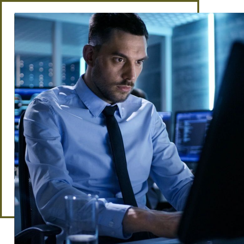 A man in a blue shirt and tie looking at the computer screen.